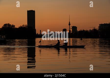 Berlin, Germany. 22nd Mar, 2022. Two rowers enjoy the sunset from the water in Plänterwald. Credit: Paul Zinken/dpa/Alamy Live News Stock Photo