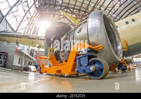 The engine of the aircraft is repaired, removed from the wing and installed on a technical cart Stock Photo