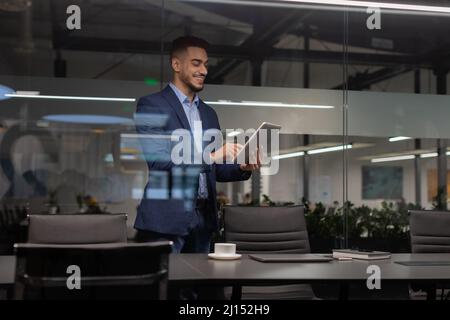 Positive middle eastern manager using digital tablet at office Stock Photo