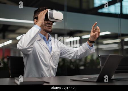 Arabic man scientist using virtual reality headset, touching copy space Stock Photo
