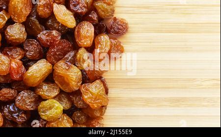 Close up picture of small raisins on a wooden background, selective focus. Stock Photo