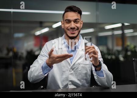 Cheerful middle eastern doctor holding glass of water Stock Photo