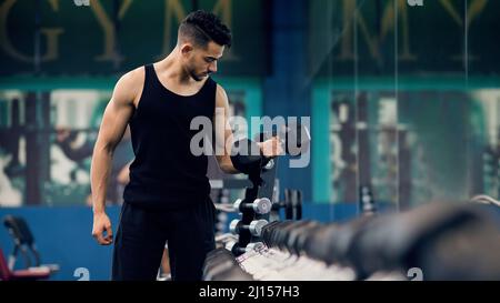 Bodybuilding Concept. Muscular Young Arab Man Training With Dumbbells At Gym Stock Photo