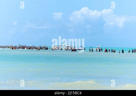 Maragogi, AL, Brazil - October 17, 2021: distant view of people walking on Moses Path, a sand bank in the middle of the sea of Barra Grande beach. Tou Stock Photo