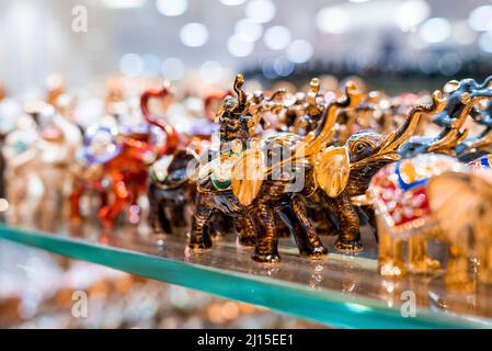 Various colorful elephant figurines display on shelf for sale in shop Stock Photo