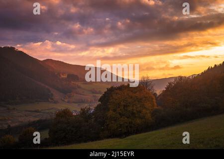 View of autumn rural landscape with colored clouds on a sky during a sunset. Stock Photo