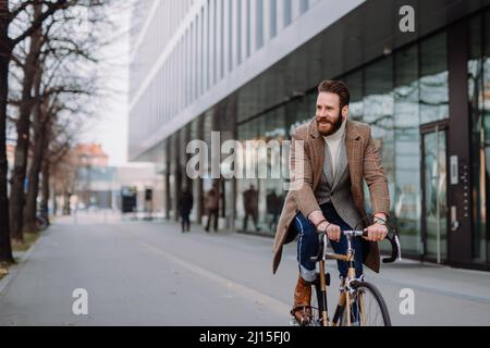 Young hipster businessman going to work on bike. Eco friendly transport concept Stock Photo
