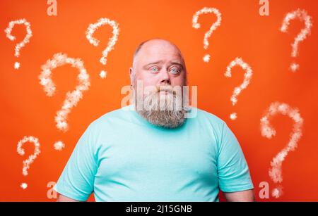 Confused man thinks something and has a lot of questions Stock Photo