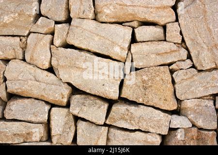 Image of a wall that is made of unevenly shaped carved stones and that are stacked unused Stock Photo