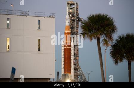 NASA’s Space Launch System (SLS) rocket with the Orion spacecraft aboard is seen atop a mobile launcher as it rolls past the Rocco A. Petrone Launch Control Center on its way to Launch Complex 39B for the first time, Thursday, March 17, 2022, at NASA’s Kennedy Space Center in Florida. Ahead of NASA’s Artemis I flight test, the fully stacked and integrated SLS rocket and Orion spacecraft will undergo a wet dress rehearsal at Launch Complex 39B to verify systems and practice countdown procedures for the first launch. Photo Credit: (NASA/Joel Kowsky) Stock Photo