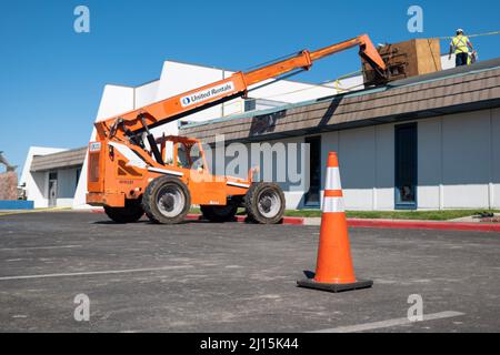 PORT ARANSAS, TX - 29 JAN 2020: Orange hydraulic forklift is used at a building where the roof is being repaired after damage from Hurricane Harvey. Stock Photo