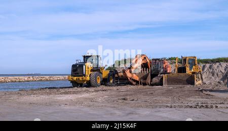 PORT ARANSAS, TX - 2 FEB 2020: Earth moving machines parked near the sand dunes at the South Jetty at the Gulf of Mexico. Stock Photo