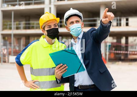 Civil engineers in masks checking work process Stock Photo
