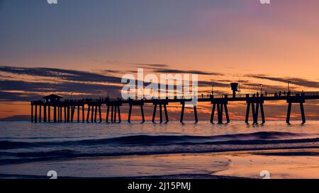 People walking on a fishing pier at sunset in the Gulf of Mexico in Fort Walton Beach, near Destin Florida, USA. Stock Photo