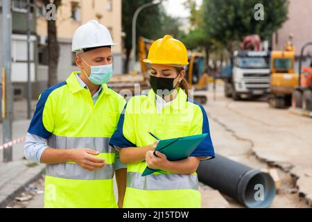Civil engineers in masks checking work process Stock Photo