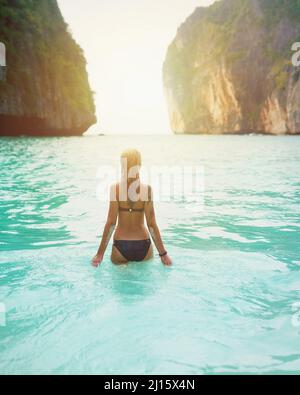 The best days are bikini days. Rear view shot of a beautiful young woman in a swimsuit walking into the ocean. Stock Photo