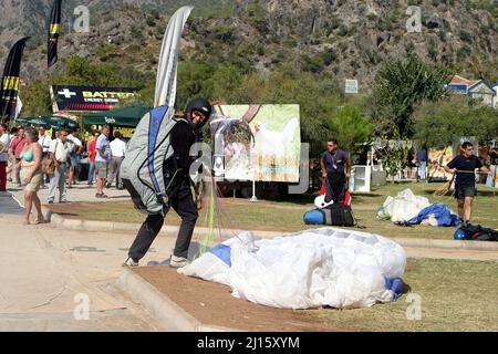 FETHIYE, TURKEY - OCTOBER 22: Paraglider collect to parachute at Fethiye Beach, October 22, 2003 in Fethiye, Turkey. Every year many air sportsmen attend to Fethiye Air Festival. Stock Photo