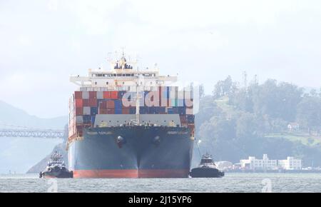 Oakland, CA - Feb 14, 2022: Tugboats assisting APL cargo ship PRESIDENT CLEVELAND maneuver into the Port of Oakland, the fifth busiest port in the Uni Stock Photo