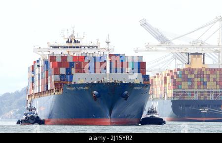 Oakland, CA - Feb 14, 2022: Multiple Tugboats assisting APL cargo ship PRESIDENT CLEVELAND to turn maneuver into the Port of Oakland. Stock Photo