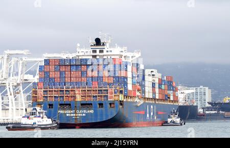 Oakland, CA - Feb 14, 2022: Tugboats DELTA BILLIE and Z-FOUR assisting APL cargo ship PRESIDENT CLEVELAND to turn 180 degrees prior to docking at the Stock Photo