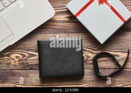 A black men's wallet lies on a wooden textured background Stock Photo