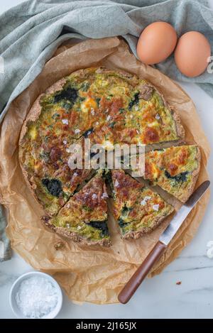 home made quiche with wild garlic on a table Stock Photo