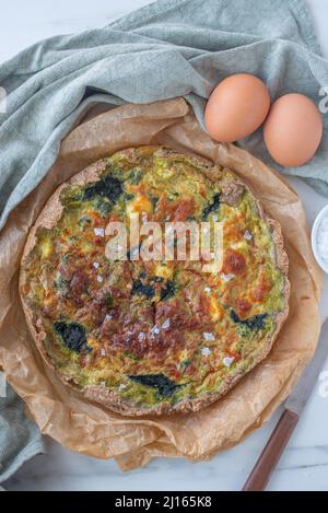 home made quiche with wild garlic on a table Stock Photo