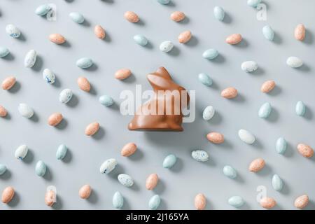 Easter chocolate eggs and rabbit on blue background. View from above. Concept Easter eggs hunt. Flat lay. Stock Photo