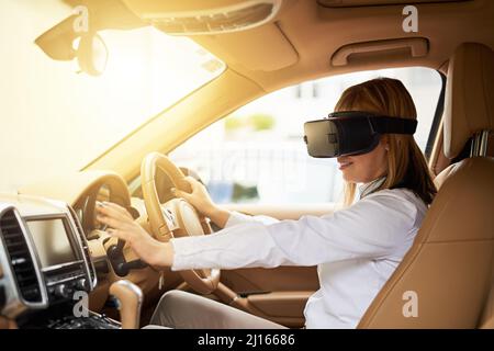 Its just like driving for real. Shot of a young businesswoman wearing a virtual reality headset while driving her car. Stock Photo