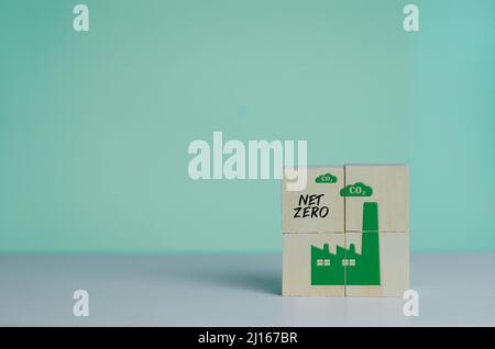 Wooden cube with industrial factory icon net zero. Eco-friendly business and development concept on background. Stock Photo