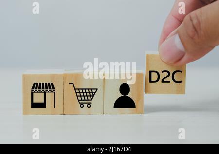 Hand put wooden cubes with Direct to Consumer D2C on table and copy space.Business concepts. Stock Photo