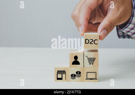Hand put wooden cubes with Direct to Consumer D2C on table and copy space.Business concepts. Stock Photo