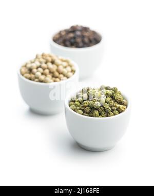 Three different types of pepper spice. Green, white and black peppercorn in the bowls. Stock Photo