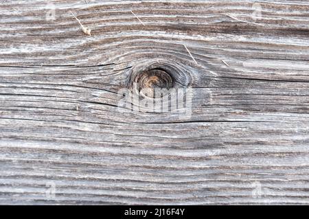 The surface of an old, brown, wooden board with a place from the branch, similar to the eye. Stock Photo