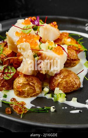 Roasted cod fillet with deep fried spring potato Stock Photo