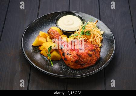 Whole roasted chicken thigh with potato wedges and pickled cabbage Stock Photo