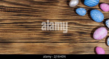 Collection of Easter eggs. Chicken eggs, painted blue and pink, lie on a stylish wooden background. Creative greeting card with Easter. Banner. Frame. Stock Photo