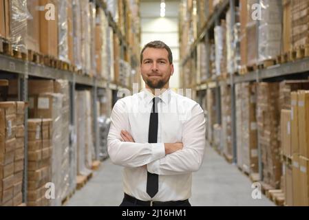portrait friendly businessman/ manager in suit working in the warehouse of a company Stock Photo