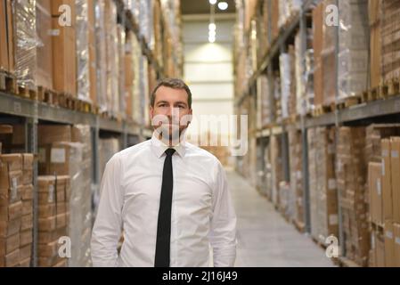 portrait friendly businessman/ manager in suit working in the warehouse of a company Stock Photo