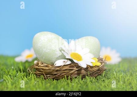 Easter background. Selective focus. Easter eggs in a basket on a meadow with flowers, against the background of the sky. Easter card concept. Copy spa Stock Photo