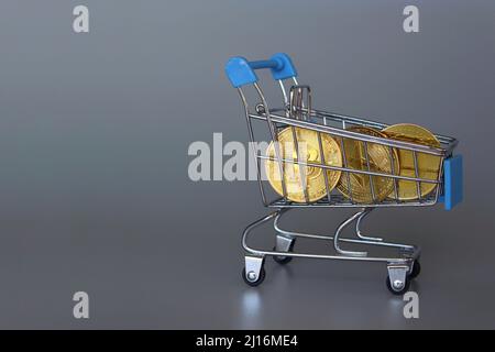 Shopping trolley and cryptocurrency. Bitcoin, Dogecoin and Ethereum. Grey background. Copy space Stock Photo