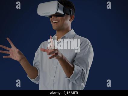 Indian man wearing vr headset against copy space on blue background Stock Photo