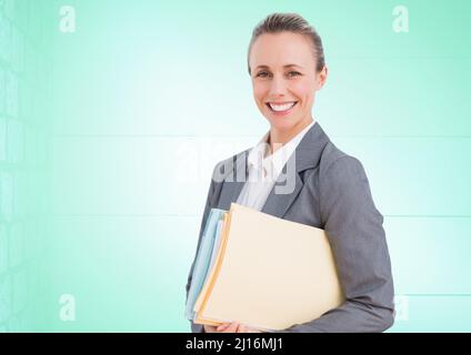 Portrait of caucasian businesswoman holding files and smiling against copy space on green background Stock Photo