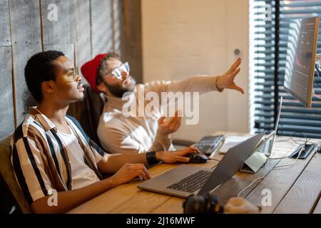 Two men working on computer at home office Stock Photo