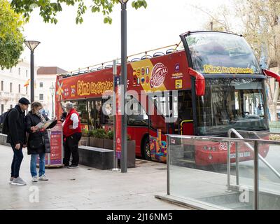 Palma de Mallorca, Spain; March 22nd 2022: Palma city sightseeing red touristic bus parked at Paseo del Borne in Palma de Mallorca. Ticket sellers and