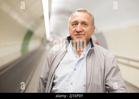 Middle aged man on moving walkway Stock Photo
