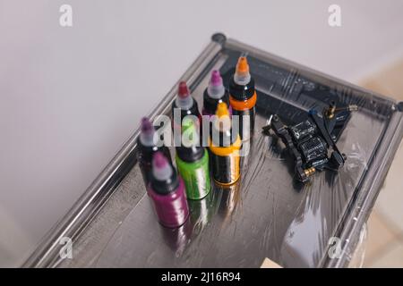 Tattoo machine and bottles of colored ink. Various colors. Tattoos. Stock Photo