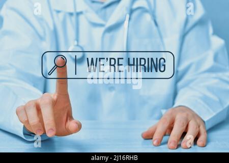 Search bar with the text we are hiring on the background of a doctor touching an abstract display. Medical staff Stock Photo