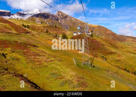 Grindelwald, Switzerland - October 10, 2019: Cable car cabins Jungfrau Top of Europe and autumn Swiss Alps mountains panorama landscape Stock Photo