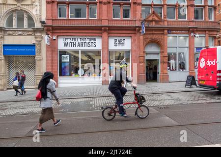 Cyclist on the Tramlines avoiding Shoppers in Birmingham City Centre Stock Photo